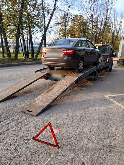 Погрузка седана по аппарелям, выставлен знак аварийной остановки